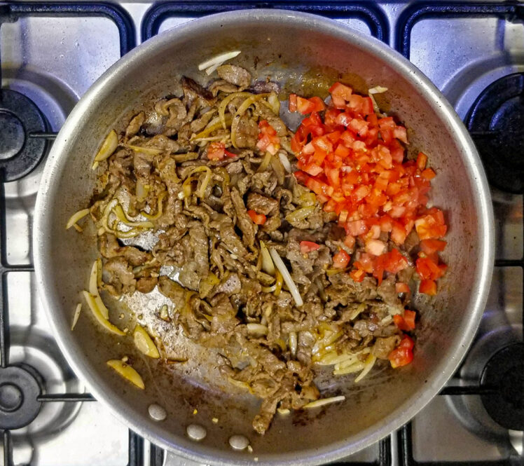 Lägg de hackade tomaterna i stekpannan