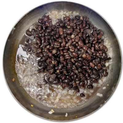 Tillsätt bönorna till löken och vitlöken