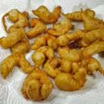 Låt de färdigfriterade räkorna rinna av på ett papper