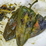 Repetera på alla poblanos tills det mesta av skinnet är borta.