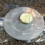 Lägg degbollen på en plastbit på tortillapressen