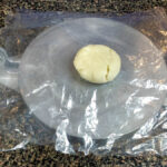 Lägg även plast på degbitens ovansida så att degen inte fastnar i tortillapressen