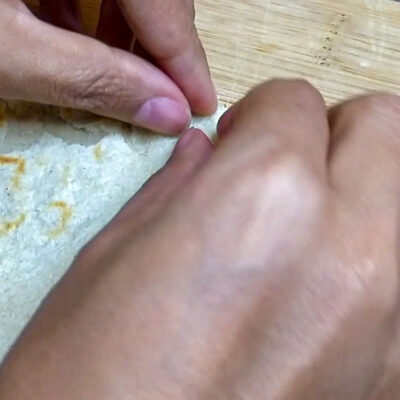 Nyp ihop tortillans kanter mellan tumme och pekfinger