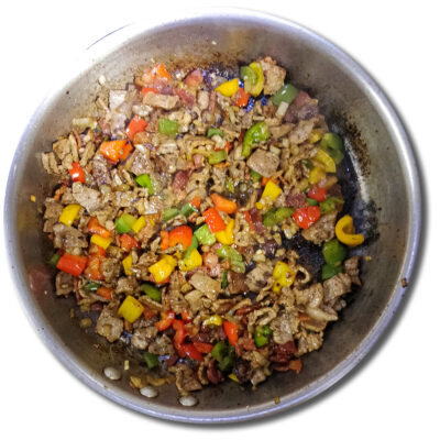 Lägg tillbaka bacon, paprika och lök i stekpannan igen ochj låt allt bli varmt under omrörning