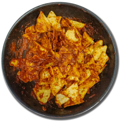 Chilaquiles redo att toppas med tillbehör och sedan serveras