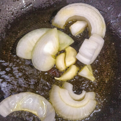 Skär löken i stora bitar och stek den mjuk tillsammans med vitlöksklyftorna i oljan