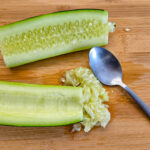 Dela gurkan på mitten och ta ut kärnhuset med en sked