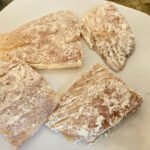 Vänd fisken i mjöl och skaka av det överflödiga.